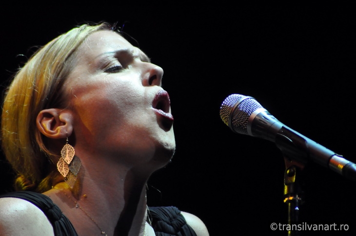 Blonde woman singing in microphone